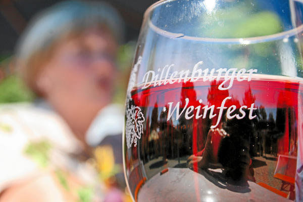 Im Vordergrund ein graviertes Rotweinglas mit der Aufschrift "Dillenburger Weinfest" im Hintergrund ist ein Mensch erkennbar. Mit Klick aufs Bild gehts zur Veranstaltung.